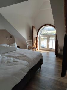 1 dormitorio con 1 cama grande y un arco en Landapartments Smitmans, en Kerken