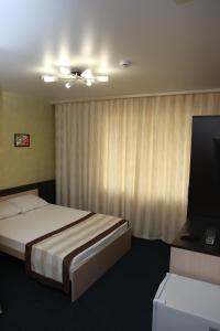 エカテリンブルクにあるアミーゴ ホテルのベッドとテレビが備わるホテルルームです。