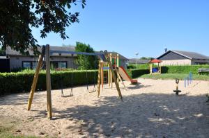 een speeltuin met een schommel in het zand bij Boerenslag 10 in Sint Maartensvlotbrug