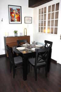 a black dining room table with chairs and glasses on it at Superbe T3 Terrasse Coeur de Paris historique in Paris