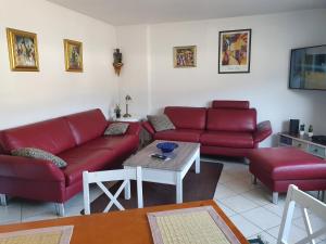 una sala de estar con sofás rojos y una mesa. en Ferienwohnung an der Fähre St. GOAR, en Sankt Goar