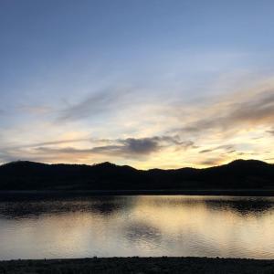 een zonsondergang boven een grote hoeveelheid water bij Los Arces in Elosu