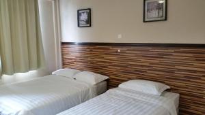 dos camas sentadas una al lado de la otra en una habitación de hotel en Hotel Sri Iskandar, en Kota Kinabalu