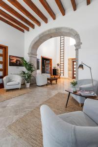 una sala de estar con muebles blancos y un arco en Finca Son Arnau, en Selva