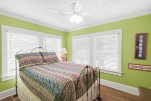 a bedroom with green walls and a bed with a fan at Heron's Watch in Grayton Beach +42 photos
