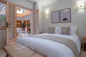 a bedroom with a large white bed and a table at Riad Le Saadien ,Adult only in Marrakesh +80 photos