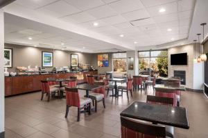 a restaurant with tables and chairs and a bar at Comfort Suites Forsyth near I-75 in Forsyth