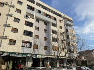 a white building with cars parked in front of it at Exclusive studio, great location in Podgorica