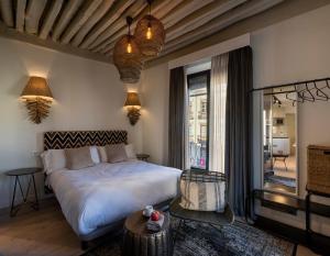 a bedroom with a white bed and a window at Cuchilleros 1 in Granada