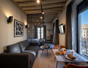 ein Wohnzimmer mit einem Sofa und einem Tisch in der Unterkunft Home4u, Plaza nueva 1 in Granada
