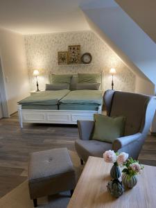 a bedroom with a bed and a couch and a table at Café Ilse - Ferienwohnungen in Ranis