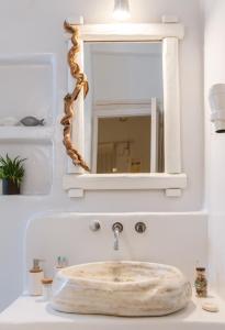 lavabo con espejo y lavabo de mármol en Vincenzo Family Rooms, en Tinos