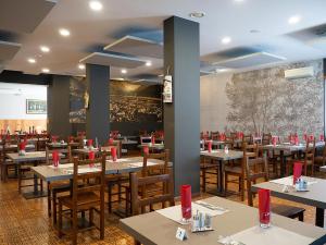 a restaurant with tables and chairs with red bows at Al Benvenuto Hotel & Restaurant in Tolmezzo