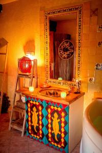 y baño con lavabo colorido y espejo. en Domaine de la croix du Vexin, en Théméricourt