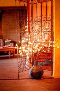 a vase in front of a gate with a plant in it at Domaine de la croix du Vexin in Théméricourt