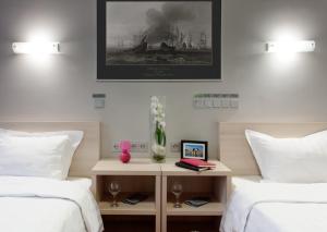une chambre avec deux lits et une photo d'un bateau dans l'établissement Marins Park Hotel Yekaterinburg, à Iekaterinbourg