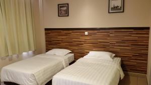 Postel nebo postele na pokoji v ubytování Hotel Sri Iskandar
