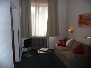 ein Wohnzimmer mit Sofa und Fenster in der Unterkunft Hotel Stadt Hamm in Hamm