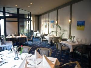 a dining room with white tables and chairs at Hotel Stadt Hamm in Hamm