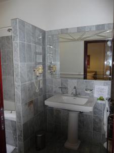 ein Bad mit einem Waschbecken und einem Spiegel in der Unterkunft Hotel Stadt Hamm in Hamm