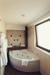 a large bath tub in a bathroom with a window at Denisa Boutique in Poiana Brasov