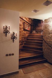 a staircase in a building with a stone wall and candles at Denisa Boutique in Poiana Brasov