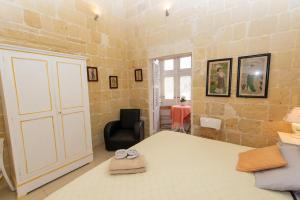 1 dormitorio con 1 cama, 1 silla y 1 puerta en Maria Townhouse Heart of Victoria B&B, en Victoria