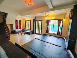 a living room with a couch and some windows at Aashiyaanaa villa "IMPERIAL" in Lonavala