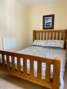 a bedroom with a wooden bed and a picture on the wall at Chalet Escapes in Kidwelly