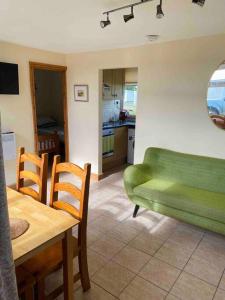 a living room with a green couch and a table at Chalet Escapes in Kidwelly