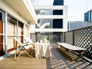 a patio with a table and chairs on a balcony at Home n Lounge in Tokyo