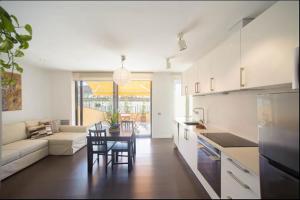 cocina y sala de estar con mesa y sofá en Apartament La Placeta Figueres, en Figueres