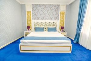 um quarto com uma grande cama branca e pisos azuis em Mensen Hotel Baku em Baku