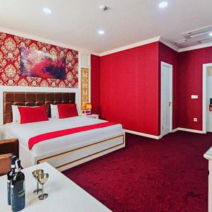 Mensen Hotel Baku في باكو: غرفة نوم بجدران حمراء وسرير كبير