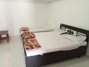 two twin beds in a room with at Narmada Homestay in Garudeshwar