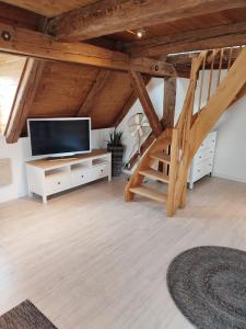 a living room with a flat screen tv and a staircase at Altstadt Appartements in Landsberg am Lech