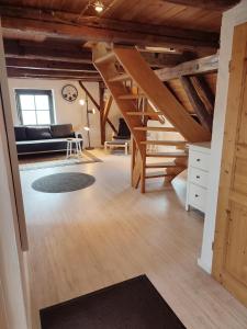 a living room with wooden ceilings and a staircase at Altstadt Appartements in Landsberg am Lech