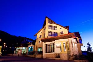 a building at night with a blue sky at Denisa Boutique in Poiana Brasov