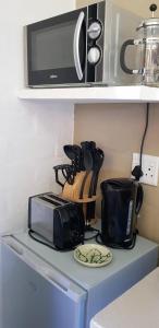 a microwave sitting on top of a kitchen counter at Hemel en Aarde Village Accommodation in Hermanus