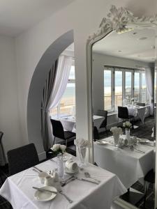 a dining room with white tables and a mirror at The Strand Hotel in Blackpool