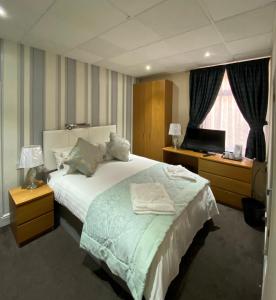 a hotel room with a bed and a television at The Strand Hotel in Blackpool