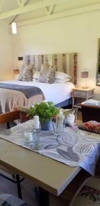 a room with a table with a bed in the background at Hemel en Aarde Village Accommodation in Hermanus