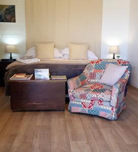 a bedroom with a bed and a couch and a chair at Hemel en Aarde Village Accommodation in Hermanus