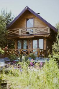 a small wooden house with a porch and windows at Domki na Górniej Łące - Domek Górny in Łazany