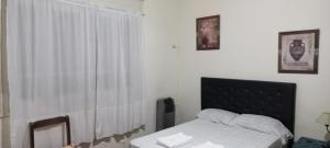 コンセプシオン・デル・ウルグアイにあるUrquiza 575のベッドルーム1室(ベッド1台付)、窓(カーテン付)