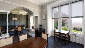 a waiting room with tables and chairs and windows at Sunbank House Metro Hotel in Perth