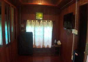 a room with a window with a curtain and a television at Ban Mai Suay Resort Pak Chong in Nong Nam Daeng