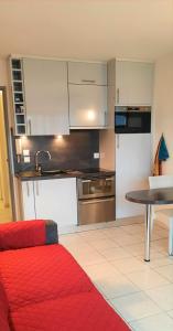cocina con cama roja y mesa en STUDIO PORT VAUBAN vue port excellente situation climatisé Fibre, en Antibes