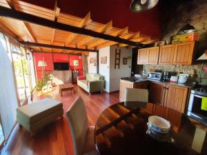 cocina y sala de estar con mesa de madera y comedor en Green House en El Calafate