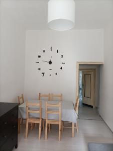 a dining room with a table and a clock on the wall at Il Borgo in Corbara